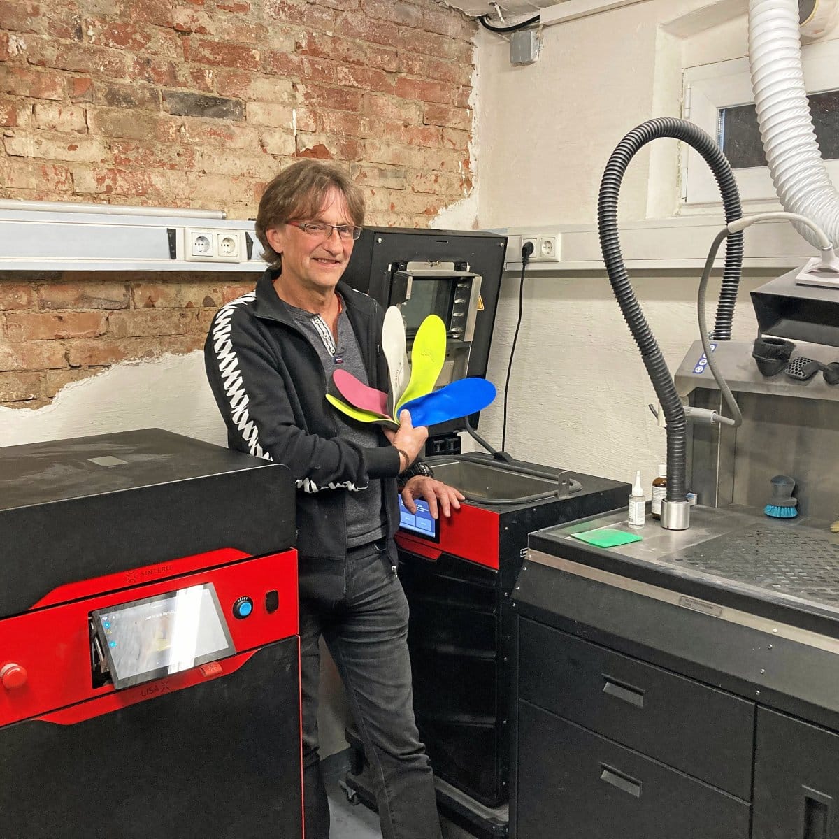 Peter Hartung mit 4POINT Maßeinlagen vor einem SLS-3D-Drucker